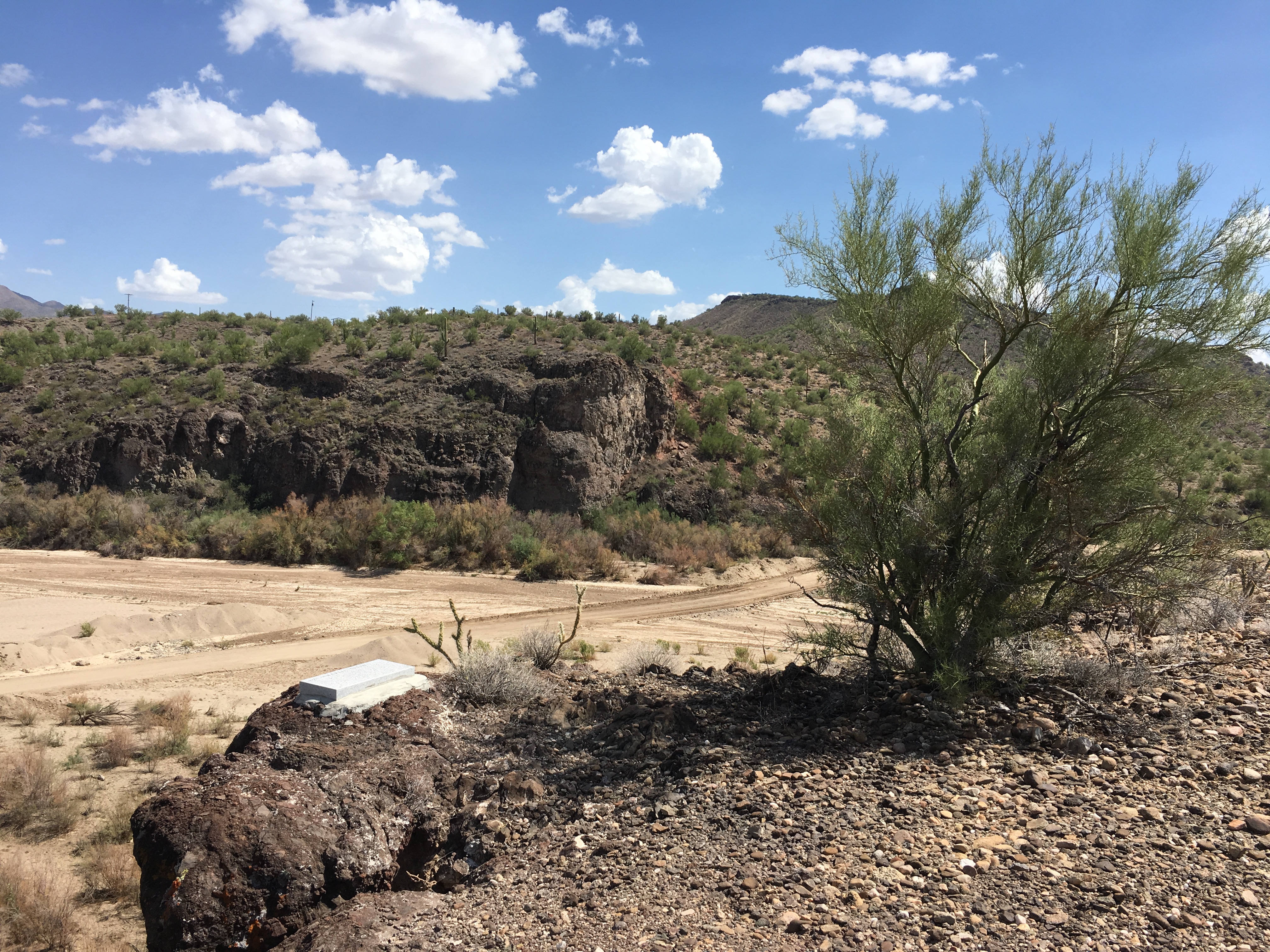 An overlook of a dirt road crossing a creekbed..