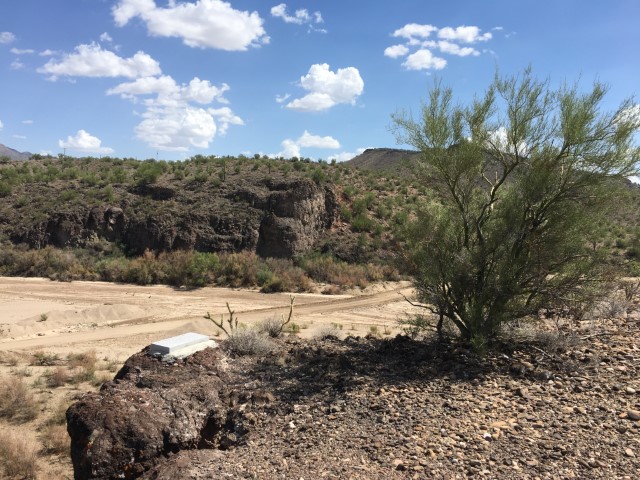 An overlook of a dirt road crossing a creekbed..