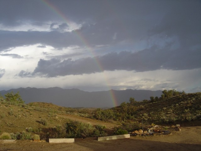A thunderstorm over wilderness with a rainbow..