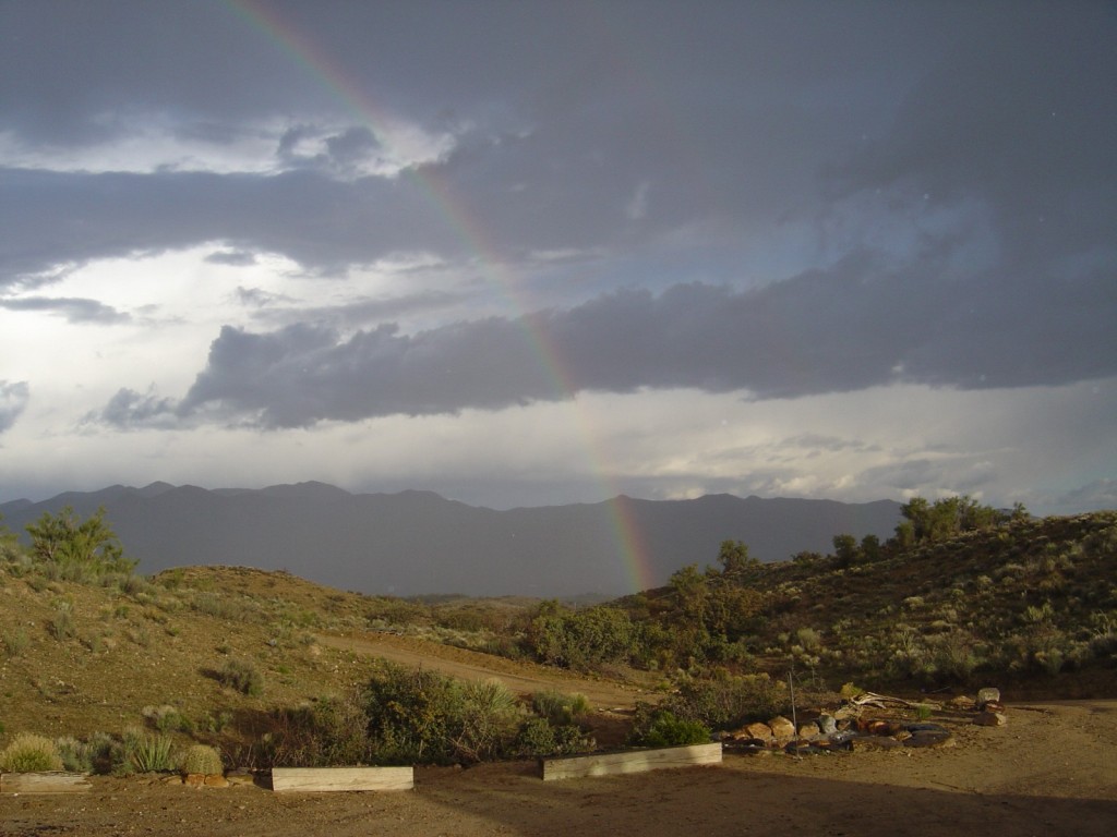 A thunderstorm over wilderness with a rainbow..