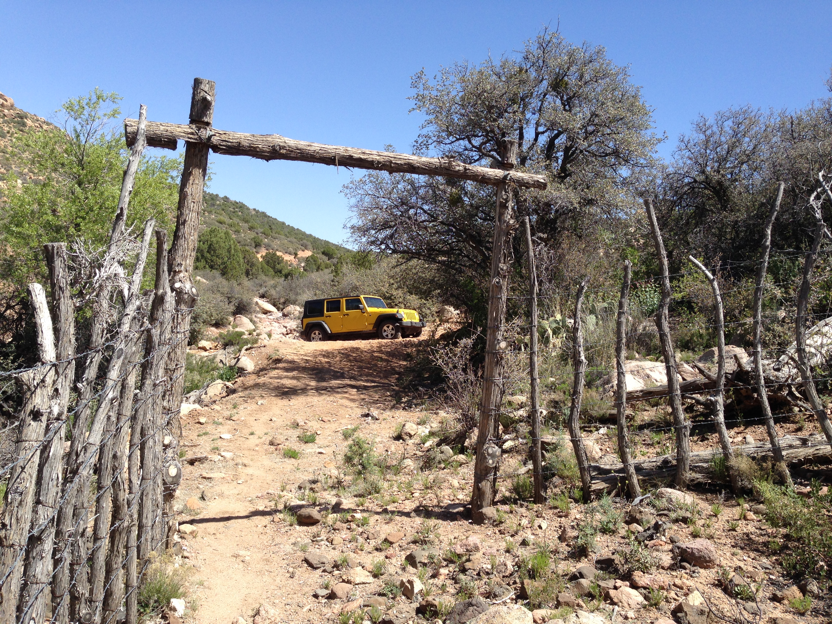 A yellow jeep parked in a wooden corral..